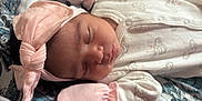 Analeia is registered to the contest to win money with this photo: baby, baby_accessories, baby_clothing, blanket, closeup, cute, headband, indoor, infant, mittens, newborn, onesie, patterned_blanket, peaceful, pink_bow, portrait, resting, sleep, sleeping, soft_fabric