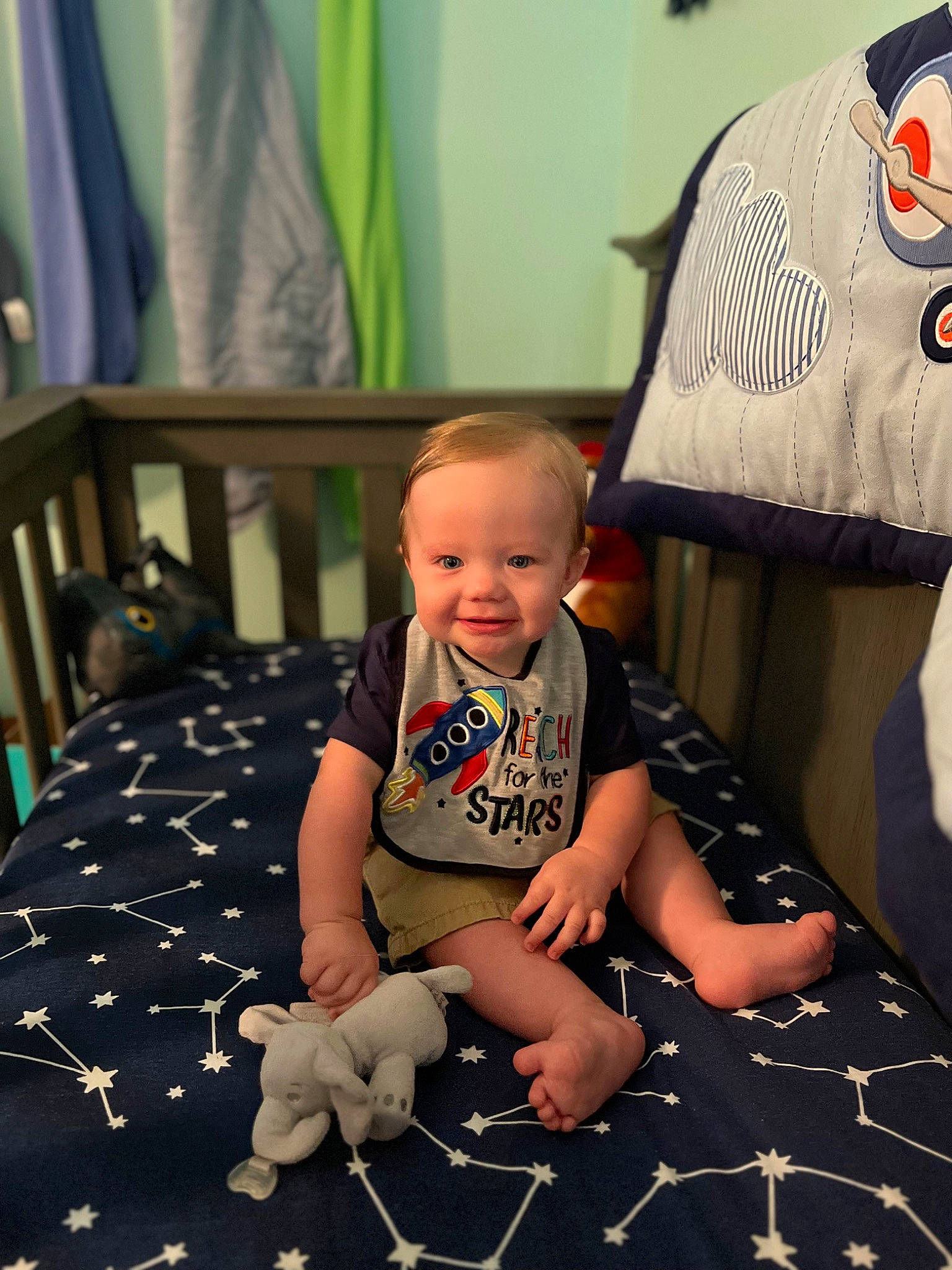 Gavin is registered to the contest to win money with this photo: baby, baby_toddler_clothing, black, chair, child, curtain, flooring, fun, green, happy, joy, mammal, pattern, person, room, shorts, sleeve, smile, t_shirt, toddler