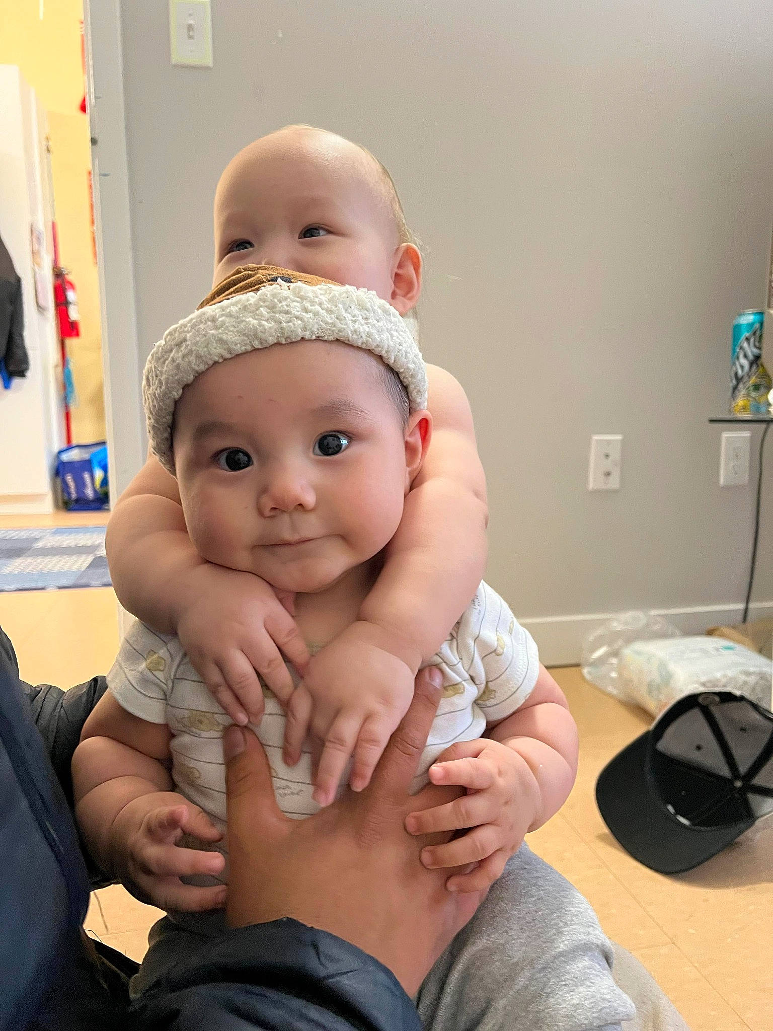 Johnny is registered to the contest to win money with this photo: abdomen, baby, baby_toddler_clothing, cheek, comfort, eye, foot, fun, gesture, hand, happy, hat, headwear, human_leg, knee, nail, person, skin, thigh, thumb