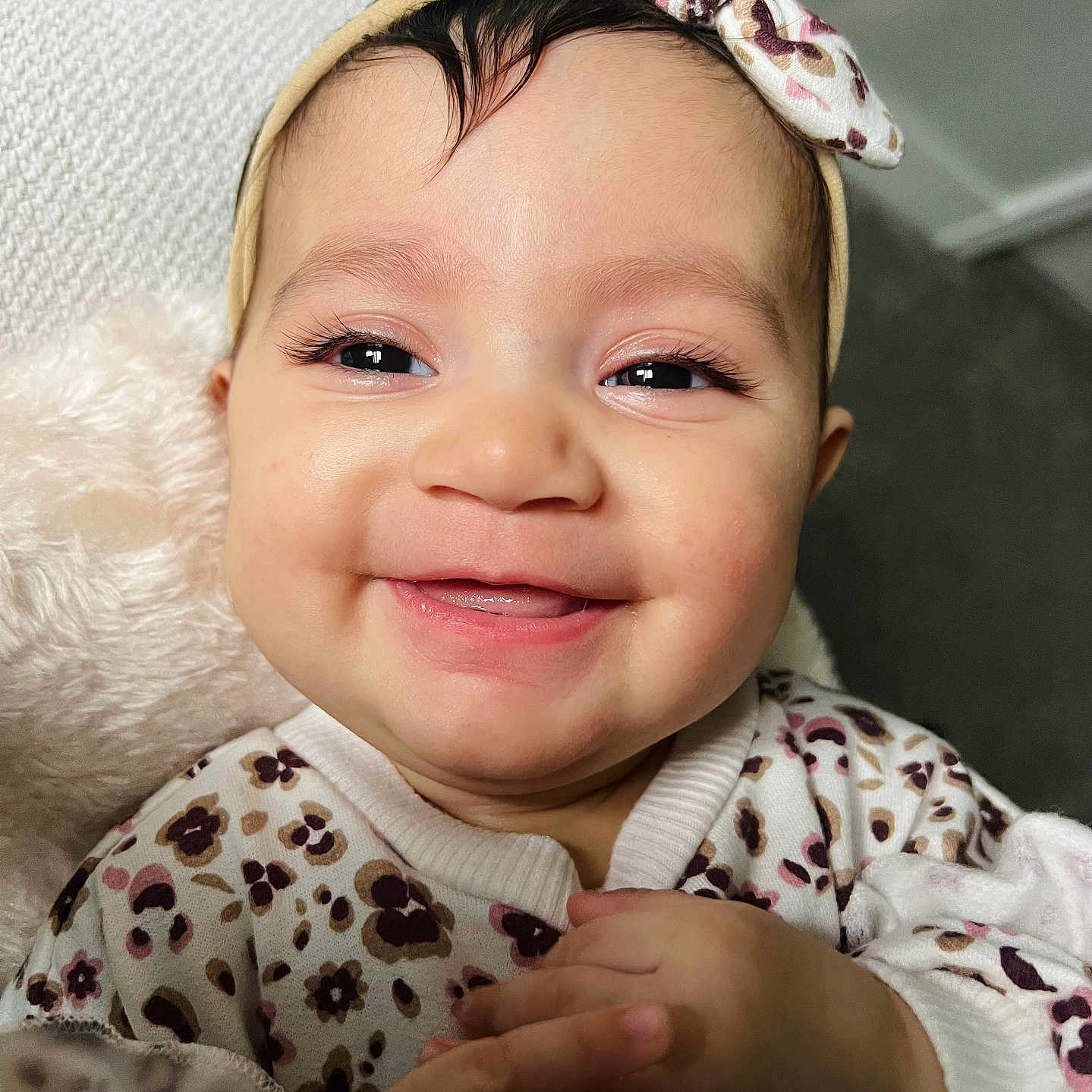 Elisianna joined the competition — help win amazing prizes! apparel, baby, child, closeup, clothing, cozy, cute, eyelashes, face, floral_pattern, hands, happy, headband, indoors, infant, person, portrait, skin, smiling, young