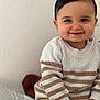 baby, casual, child, clothing, cozy, cute, face, happy, home, indoor, knitwear, light_skin, person, portrait, seated, short_hair, smiling, striped, sweater, toddler