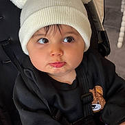 Tilyano a rejoint le concours — aidez-le/la à gagner de superbes lots ! baby, black_clothing, child, childhood, clothing, cute, drool, expression, eyes, face, hands, hat, indoor, infant, pom_pom, portrait, seatbelt, stroller, teddy_bear_patch, white_hat