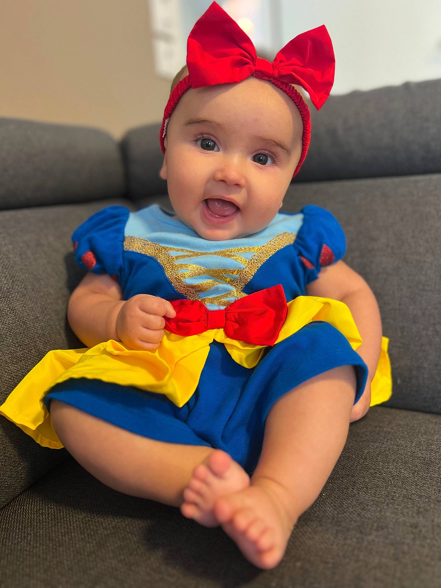 Bella participe au concours pour gagner de l'argent avec cette photo : baby, baby_toddler_clothing, cap, child, costume_hat, couch, electric_blue, face, fun, happy, head, headgear, headwear, human_leg, lap, person, sitting, skin, sleeve, smile