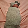 Unique joined the competition — help win amazing prizes! baby, newborn, sleeping, swaddled, blanket, hat, bow, pink_sheet, cozy, soft_fabric, infant, child, portrait, resting, cute, peaceful, indoors, human, wrapped, lying_down