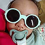 accessory, baby, baby_clothes, child, closeup, clothing, comfort, cute, face, fashion, head, indoor, infant, pacifier, portrait, relaxation, skin, soft_toy, sunglasses, young