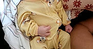 Emmanuel is registered to the contest to win money with this photo: baby, newborn, sleeping, infant, portrait, yellow_outfit, hat, onesie, animal_print, blanket, pillow, floral_pattern, bed, indoors, peaceful, resting, closed_eyes, face, child, photography