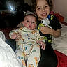 baby, child, siblings, portrait, smiling, cuddling, stuffed_animal, dog_toy, bed, bedroom, indoors, flash_photography, infant, toddler, onesie, patterned_clothing, family, happy, seated, casual_photo