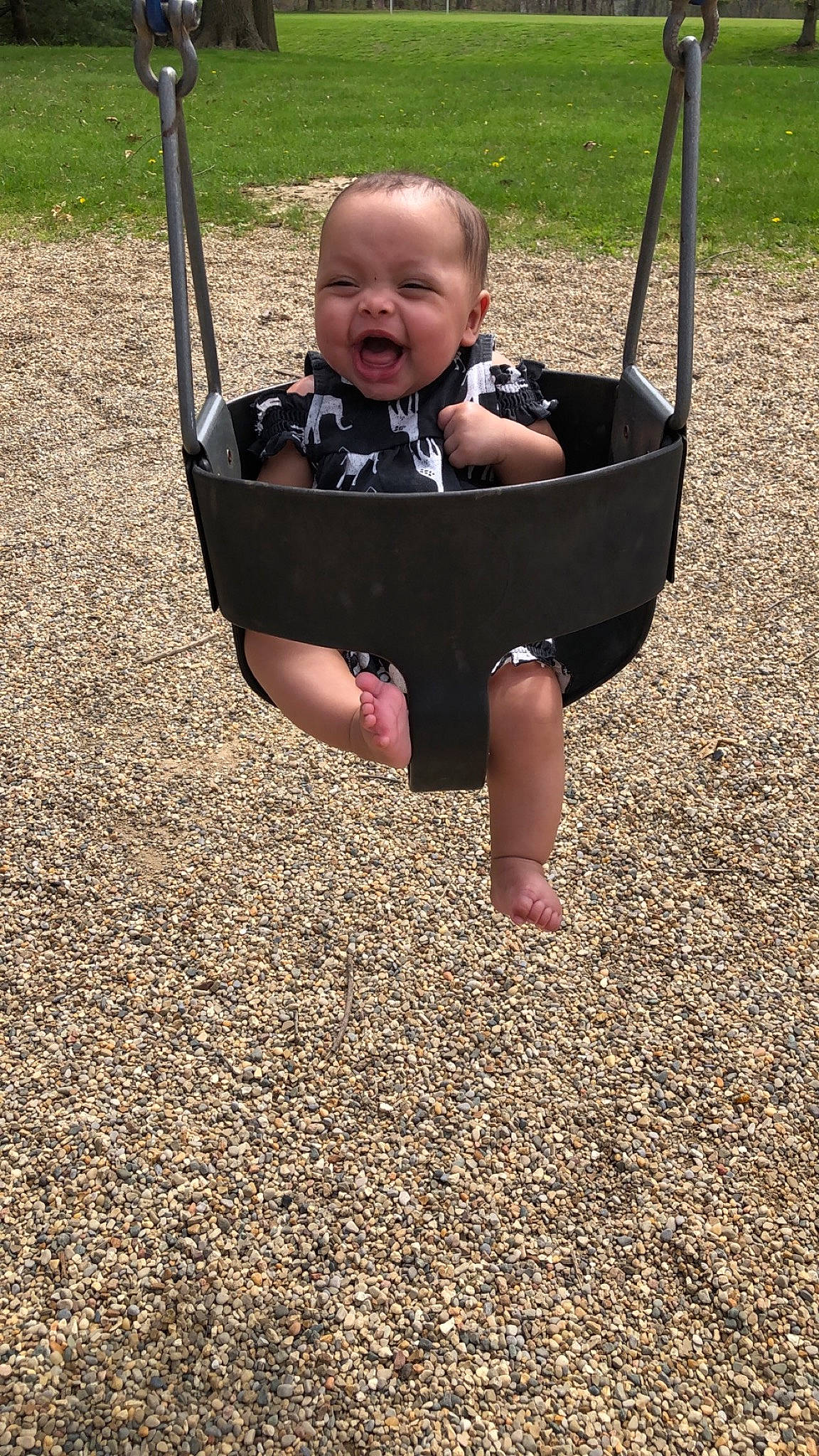 Anniya is registered to the contest to win money with this photo: baby, baby_toddler_clothing, child, city, fun, grass, happy, leisure, outdoor_play_equipment, people_in_nature, person, play, playground, recreation, sitting, smile, soil, swing, toddler, tree