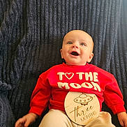 Leonidas joined the competition — help win amazing prizes! baby, blue_blanket, casual_clothing, celebration, child, cute, eyes, face, happy, infant, lying_down, milestone, portrait, red_sweater, smiling, text_on_clothing, texture, three_months, ufo_illustration, wooden_sign