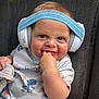 Beau is registered to the contest to win money with this photo: baby, blue_striped_band, cheeks, child, clothing, comfort, cute, dinosaur_print, expression, fabric, finger_in_mouth, headphones, indoors, infant, onesie, playful, seat, sitting, smiling, young