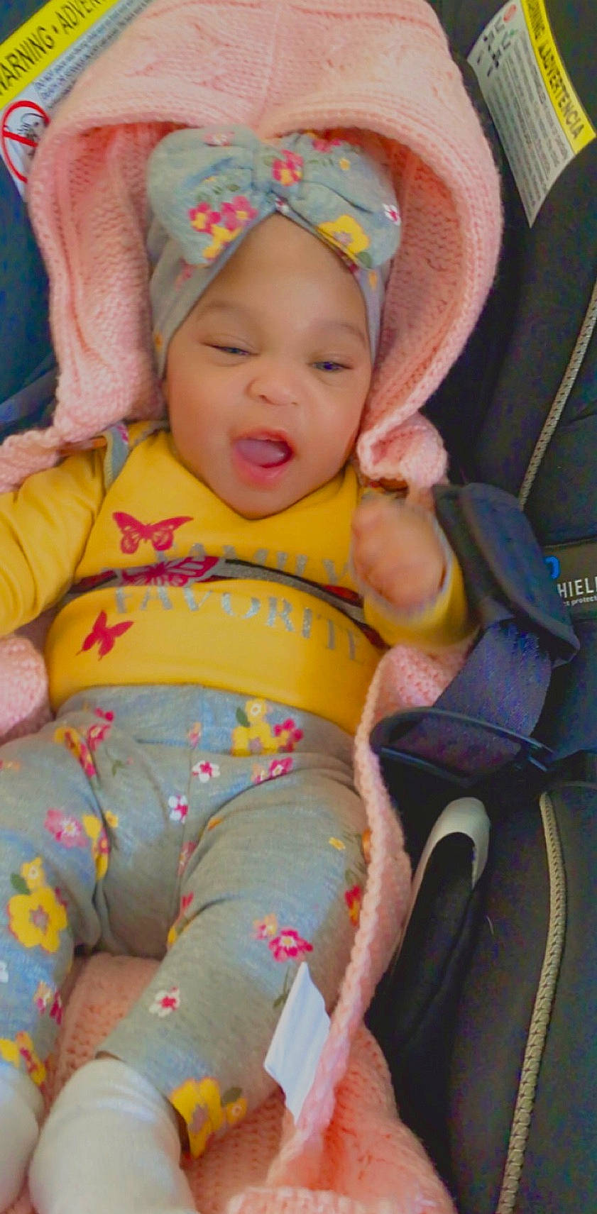 Nariah is registered to the contest to win money with this photo: baby, baby_products, baby_toddler_clothing, chair, cheek, child, comfort, eye, face, facial_expression, happy, head, headwear, lap, linens, person, pink, sitting, skin, smile