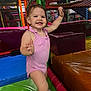 toddler, child, smiling, indoor_playground, play_area, colorful, netting, padded_mats, pink_outfit, happy, baby, person, fun, active, cute, young_child, play, safety, legs, arms