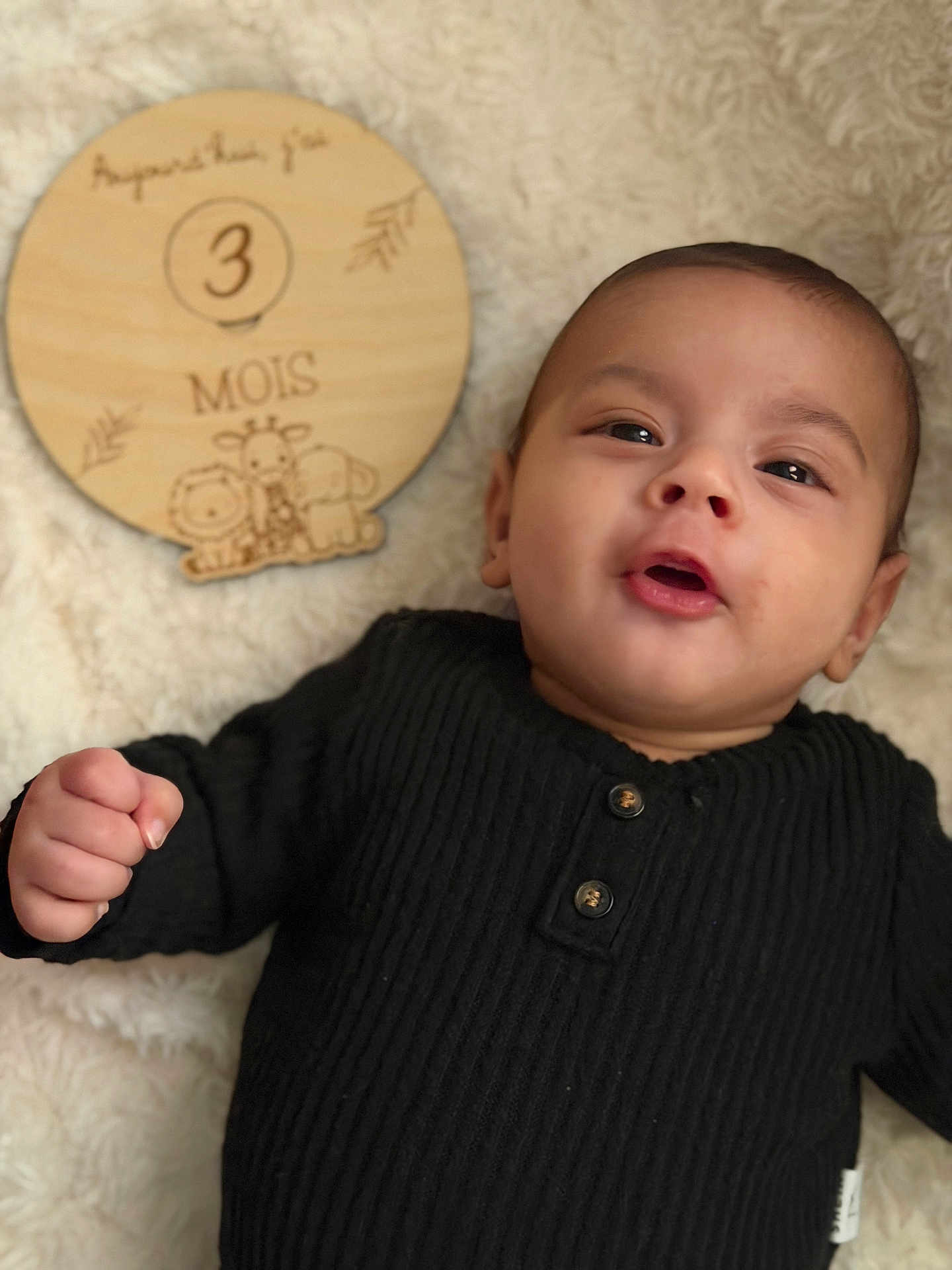 Nahyl a rejoint le concours — aidez-le/la à gagner de superbes lots ! baby, infant, black_sweater, wooden_sign, milestone, 3_months, cute, portrait, fluffy_blanket, animal_illustrations, closeup, child, young, smiling, indoors, person, newborn, happy, lying_down, soft_texture