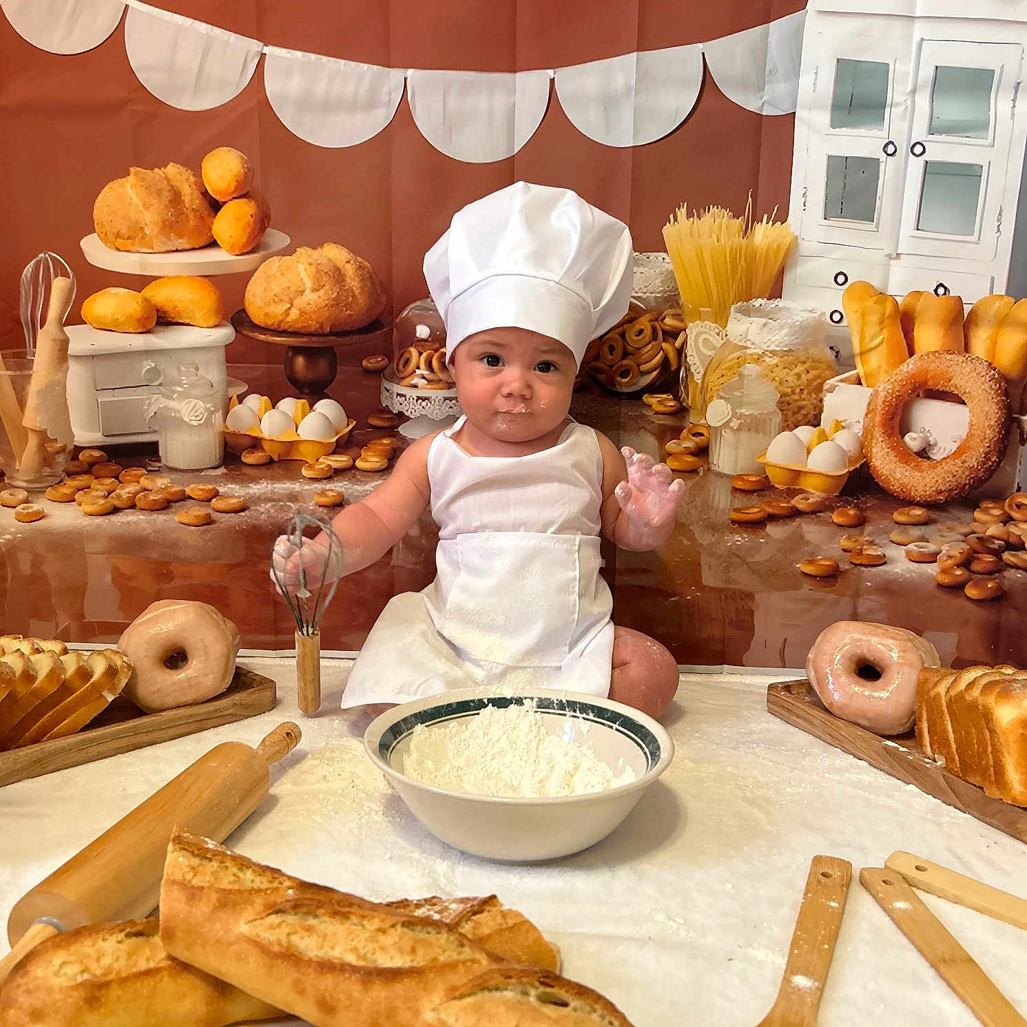 Kaleb joined the competition — help win amazing prizes! baby, chef_hat, whisk, flour, baking, bread, doughnut, eggs, kitchen_utensils, apron, table, food, cooking, cute, child, portrait, indoors, baked_goods, smiling, playful