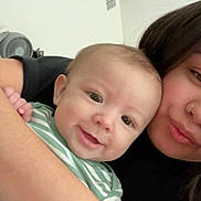 Sebastian is registered to the contest to win money with this photo: baby, child, woman, person, smile, face, arm, hair, striped_clothing, holding, indoor, skin, head, nose_ring, happy, closeup, affection, family, love, portrait