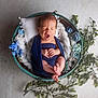 Hugo a rejoint le concours — aidez-le/la à gagner de superbes lots ! newborn, baby, yawning, wrapped, basket, blue_cloth, flowers, white_pillow, braided_fabric, greenery, foot, hand, infant, portrait, soft_lighting, studio_shot, cute, peaceful, sleepy, indoors