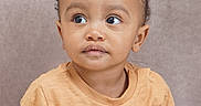 Blair-Ryser is registered to the contest to win money with this photo: baby, brown_skin, casual_clothing, child, curly_hair, cute, expression, eyes, face, head_and_shoulders, indoor, looking_away, person, portrait, shirt, short_sleeves, soft_background, studio, toddler, young