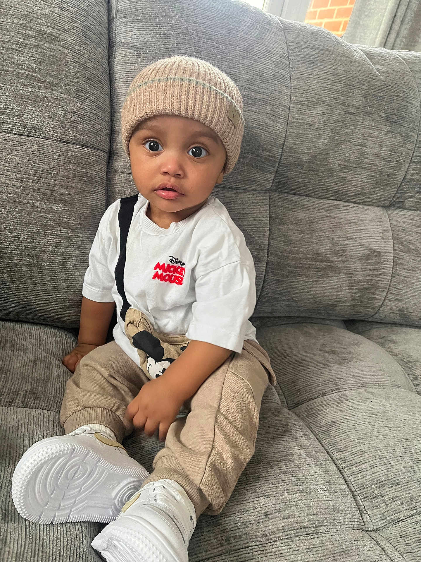 Blair-Ryser joined the competition — help win amazing prizes! beanie, beige_pants, big_eyes, casual_clothing, child, couch, cute, hat, indoor, living_room, mickey_mouse, portrait, sitting, sneakers, sofa, surprised_expression, textured_sofa, toddler, white_sneakers, white_tshirt