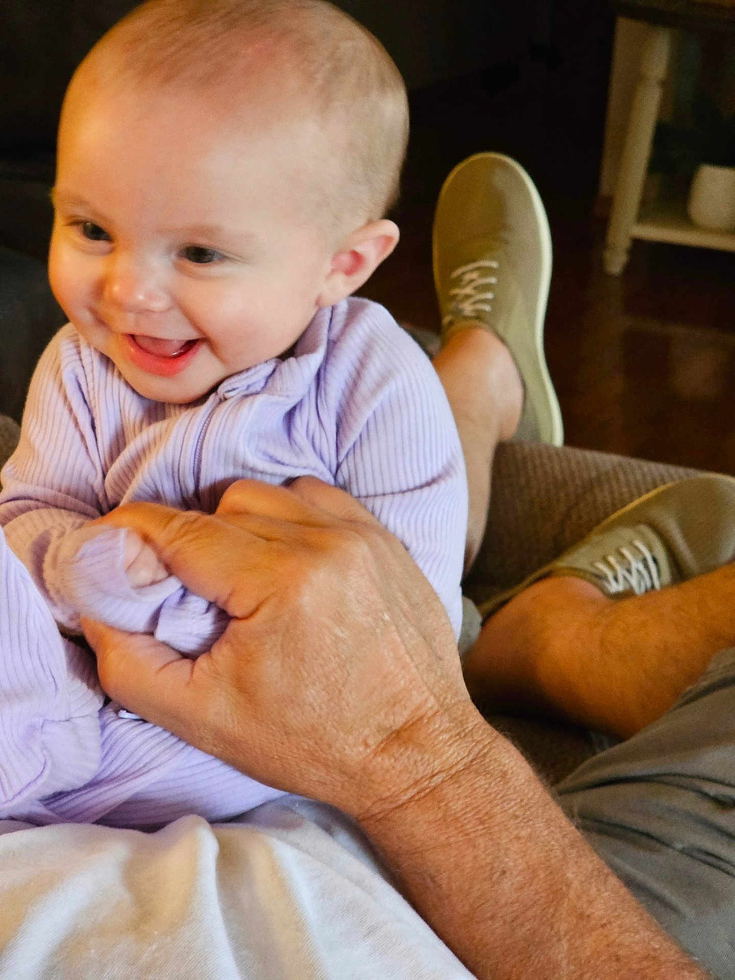 Charlotte is registered to the contest to win money with this photo: baby, child, smiling, happy, person, hand, clothing, purple, sitting, indoor, footwear, shoe, adult, skin, face, head, family, candid, cozy, joy