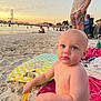 Jayce is registered to the contest to win money with this photo: toddler, beach, sand, sunset, child, toy, shovel, boogie_board, water, people, outdoor, vacation, summer, sky, clothing, person, relaxation, family, holiday, play