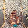 baby, sunglasses, pacifier, hammock, beach, sand, sunlight, shadow, wooden_frame, netting, toy, foot, relaxation, child, summer, outdoor, vacation, infant, cute, playful