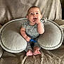 baby, blanket, child, comfort, cozy, cute, face, foot, grey_clothing, hand, happy, indoors, infant, person, plush_pillow, sitting, smiling, stitch_outfit, toy, young