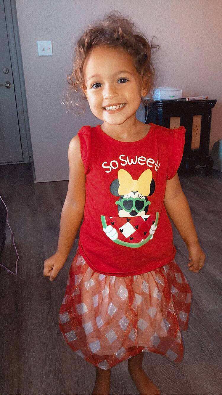 Everleigh is registered to the contest to win money with this photo: arm, baby_toddler_clothing, dress, eye, face, facial_expression, fawn, hair, happy, head, joint, joy, neck, person, pink, product, shoulder, sleeve, smile, standing