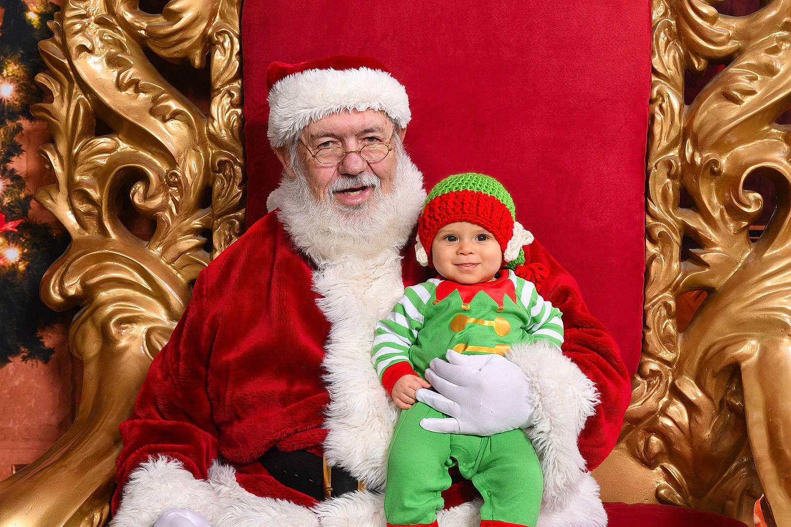 Dorian is registered to the contest to win money with this photo: christmas, christmas_decoration, event, fictional_character, headwear, holiday, joy, lap, person, santa_claus, smile, tradition