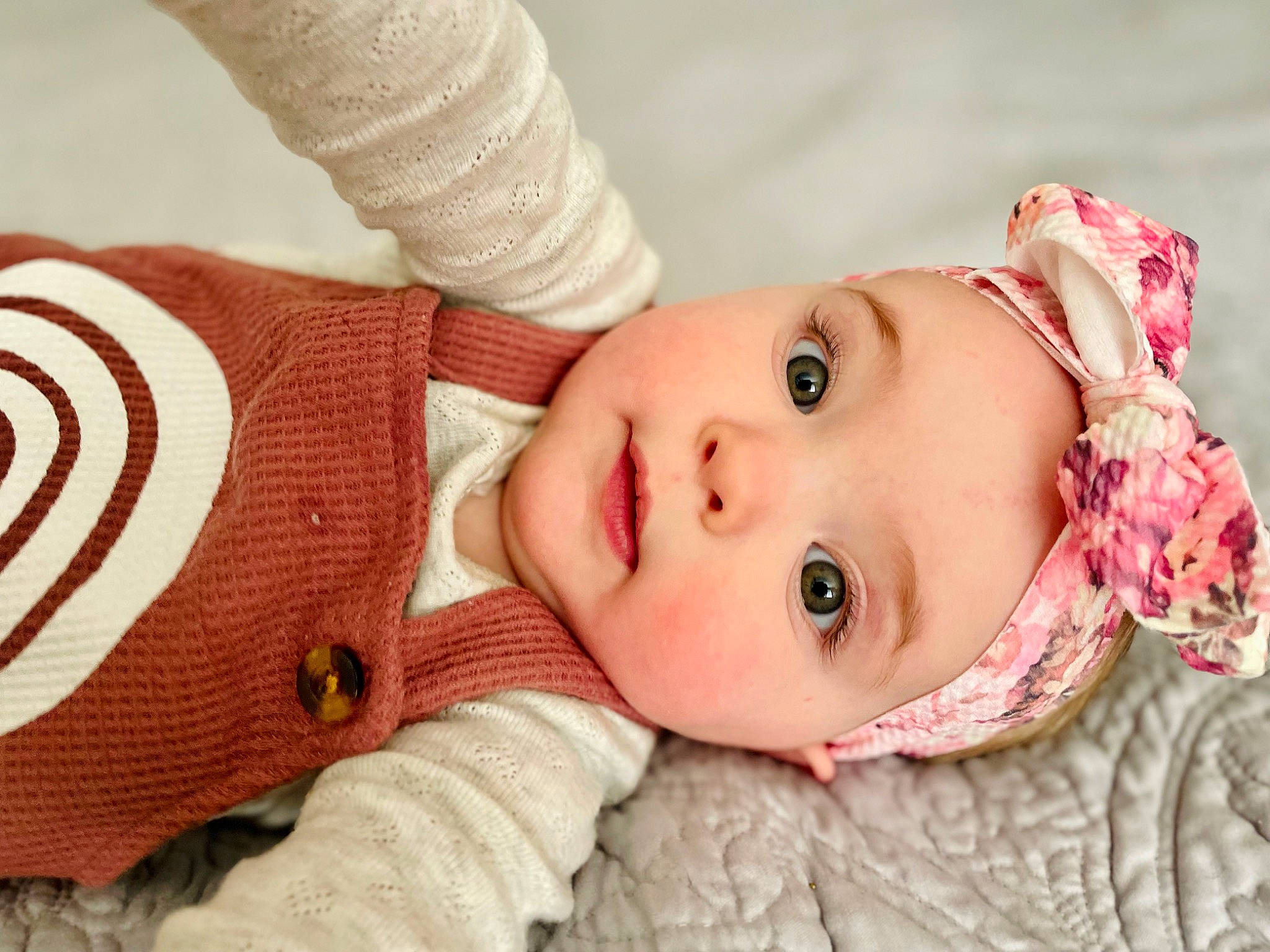 Myra is registered to the contest to win money with this photo: baby, baby_toddler_clothing, cheek, dress, eye, eyelash, face, gesture, happy, hat, head, headgear, headwear, lip, nose, pattern, person, skin, sleeve, textile
