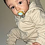 Ilyess participe au concours pour gagner de l'argent avec cette photo : baby, background, child, clothing, cute, eyes, face, footwear, hand, hoodie, indoors, infant, looking, pacifier, pants, person, portrait, sitting, sneakers, young_child
