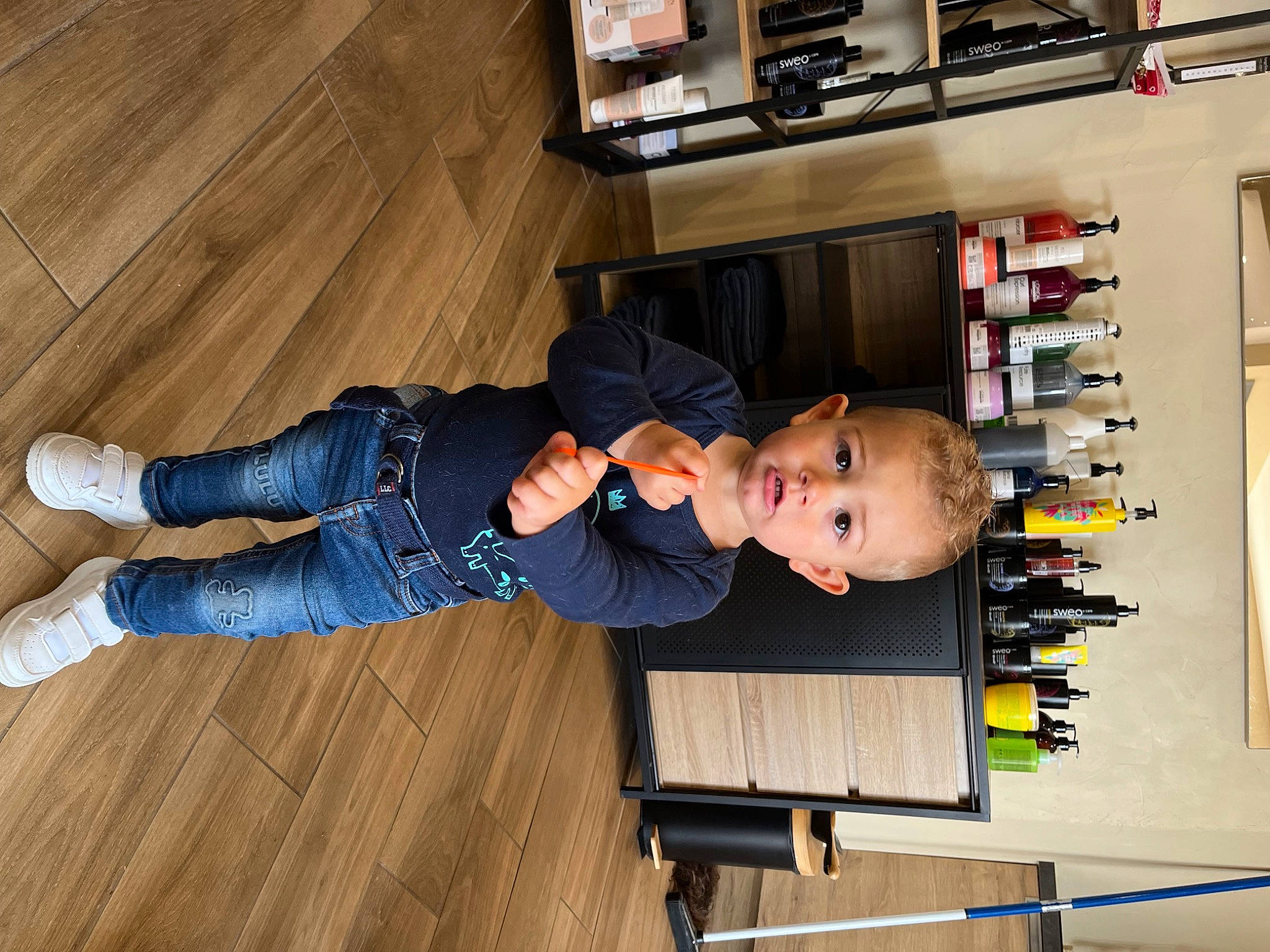 Elio a rejoint le concours — aidez-le/la à gagner de superbes lots ! baby, baby_toddler_clothing, child, comfort, floor, flooring, hardwood, laminate_flooring, machine, person, play, room, shelf, shelving, sitting, t_shirt, toddler, varnish, wood, wood_flooring