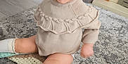 Nyla joined the competition — help win amazing prizes! child, toddler, smiling, sitting, indoors, sweater, socks, shoes, rug, floor, blanket, knitted, home, happy, cute, person, face, hair, toy, candid