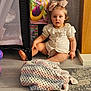 toddler, child, bow, blanket, crocheted_blanket, floor, indoor, playpen, toy, curious, sitting, clothing, puffed_sleeves, carpet, wood_floor, person, cute, blue_eyes, blonde_hair, home