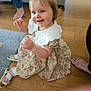 Nyla joined the competition — help win amazing prizes! toddler, child, smiling, indoor, floor, dress, bow, socks, shoes, wooden_floor, sofa, rug, happy, person, baby, portrait, candid, family, feet, home