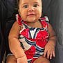 baby, child, smile, red_bow, watermelon_pattern, onesie, stroller, cute, happy, infant, chubby, portrait, person, skin, arm, hand, leg, head, eyes, clothing