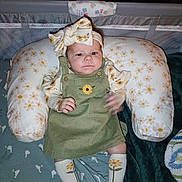 Astella is registered to the contest to win money with this photo: baby, blanket, child, clothing, comfort, crib, cute, fabric, flower_pattern, green_dress, headband, indoor, infant, mesh, person, pillow, portrait, resting, sleepwear, socks