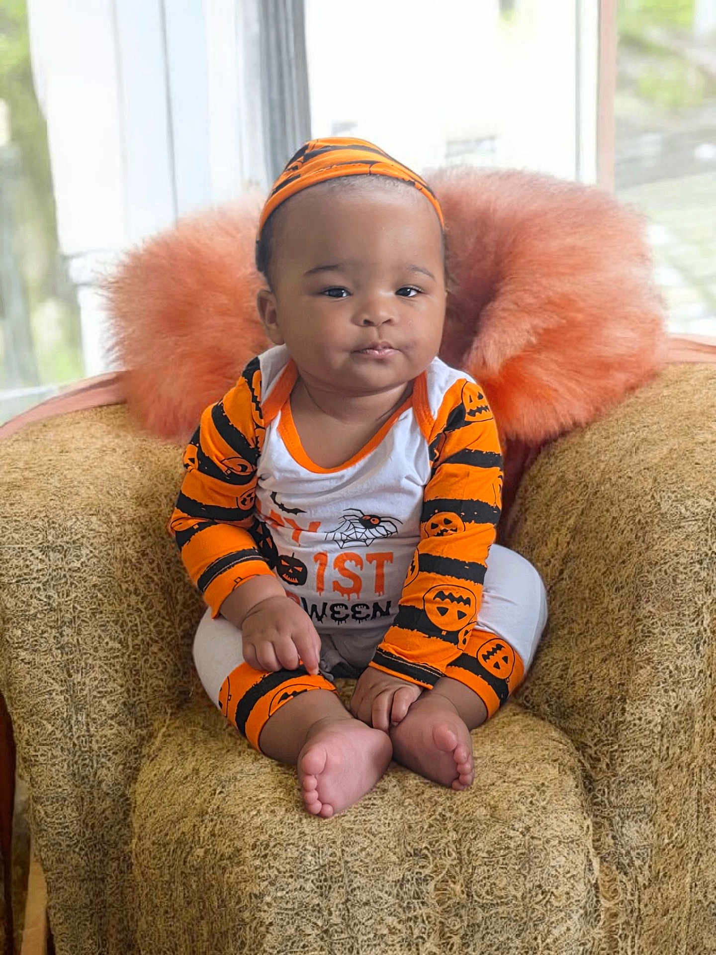 Del'Siah is registered to the contest to win money with this photo: baby, black, chair, child, clothing, costume, cozy, cute, face, foot, halloween, hand, headband, indoor, infant, orange, pillow, portrait, sitting, window