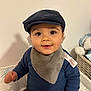 Adrien a rejoint le concours — aidez-le/la à gagner de superbes lots ! baby, child, cap, hat, bib, blue_sweater, smile, indoor, portrait, cute, face, person, sitting, plush_toy, basket, soft_lighting, clothing, young_child, cheeks, eyes