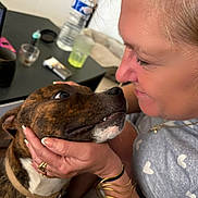 Corinne Moreira a rejoint le concours — aidez-le/la à gagner de superbes lots ! affection, bracelet, brown, casual, closeup, collar, dog, drink, expression, face, hand, indoor, interaction, love, person, pet, ring, table, white, woman