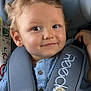 toddler, child, car_seat, seatbelt, blanket, curly_hair, smile, blue_shirt, buttoned_shirt, car_interior, safety, baby, cute, young_child, portrait, infant, hands, window, headrest, fabric