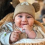baby, child, infant, smiling, hat, beanie, pom_poms, cute, cozy, blanket, clothing, face, portrait, hands, indoors, warm, soft, happy, closeup, person