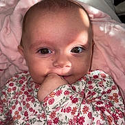 Mélina participe au concours pour gagner de l'argent avec cette photo : baby, infant, face, hand, eyes, onesie, floral_pattern, blanket, pink, skin, closeup, portrait, cute, child, newborn, sitting, indoors, soft_light, expression, young