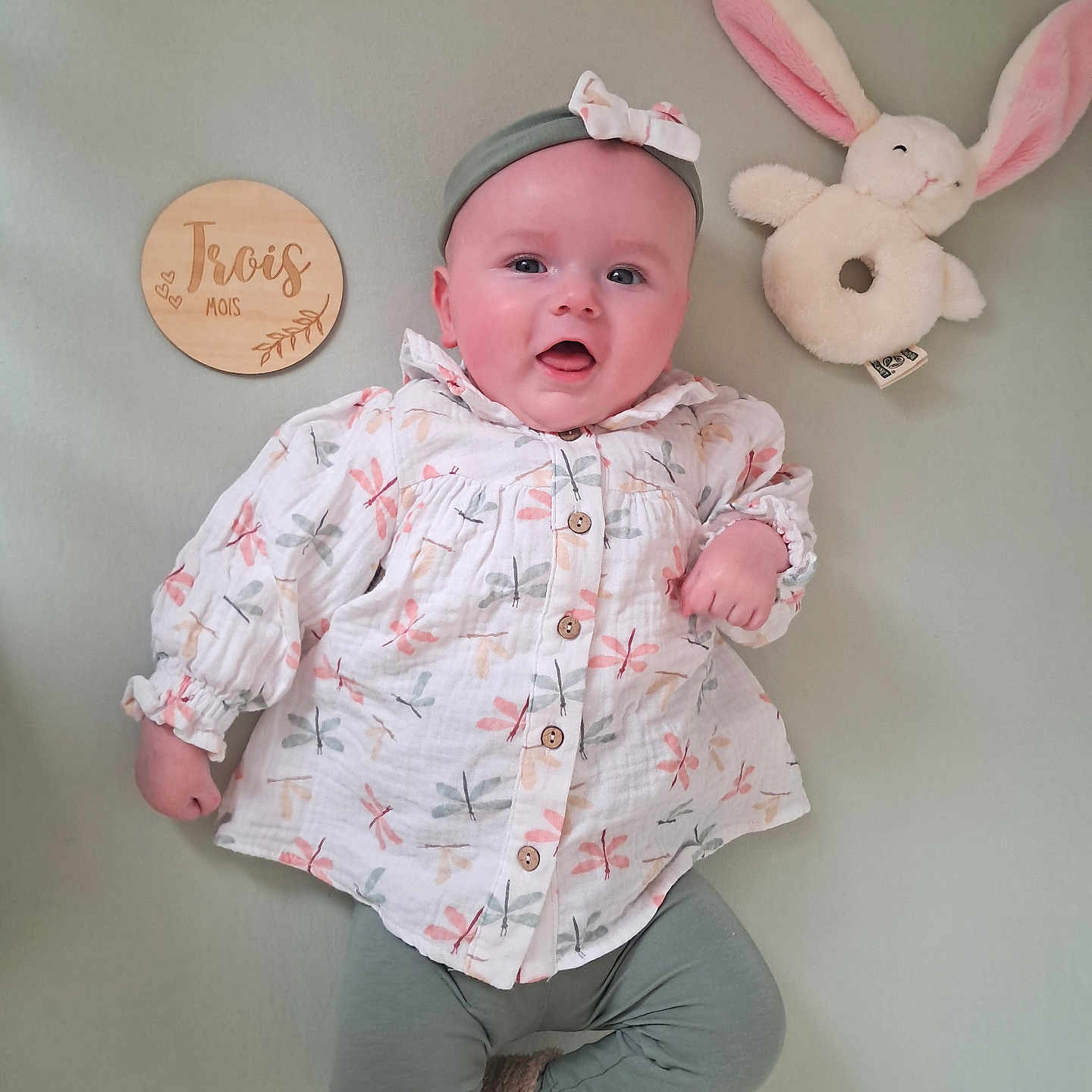 Hanaé a rejoint le concours — aidez-le/la à gagner de superbes lots ! baby, infant, child, lying_down, headband, plush_toy, bunny, wooden_plaque, clothing, long_sleeve, leggings, cute, smiling, pastel_colors, indoor, soft_surface, toy, portrait, adorable, happy