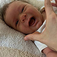 Beau is registered to the contest to win money with this photo: baby, baby_clothes, child, closeup, cute, expression, face, hand, happy, indoors, infant, joy, lying_down, newborn, person, playful, skin, smile, soft, towel