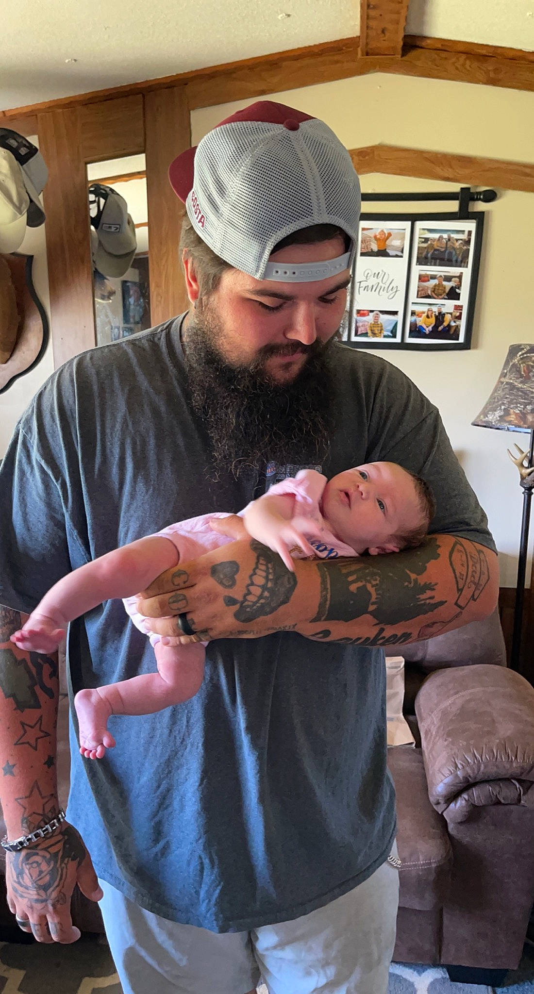 Layken is registered to the contest to win money with this photo: abdomen, baby, beard, cap, chest, comfort, elbow, eyewear, glasses, hat, headwear, mouth, muscle, person, picture_frame, purple, skin, sleeve, t_shirt, tattoo_artist