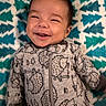 Zhenya is registered to the contest to win money with this photo: baby, child, smiling, face, onesie, hedgehog_pattern, blanket, blue, white, teal, happy, infant, cute, clothing, lying_down, portrait, young_child, cozy, indoors, expression