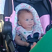 Mayra joined the competition — help win amazing prizes! baby, car_seat, child, infant, safety_harness, pink, black, blue_eyes, person, clothing, seat, child_seat, car_interior, cute, strapped_in, young_child, seatbelt, protective, infant_seat, car