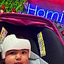 Daniella is registered to the contest to win money with this photo: baby, blue, car_seat, child, closeup, cute, flower_wall, greenery, heart_shape, helmet, indoor, neon_sign, pink, portrait, red, roses, safety, seat, straps, toddler