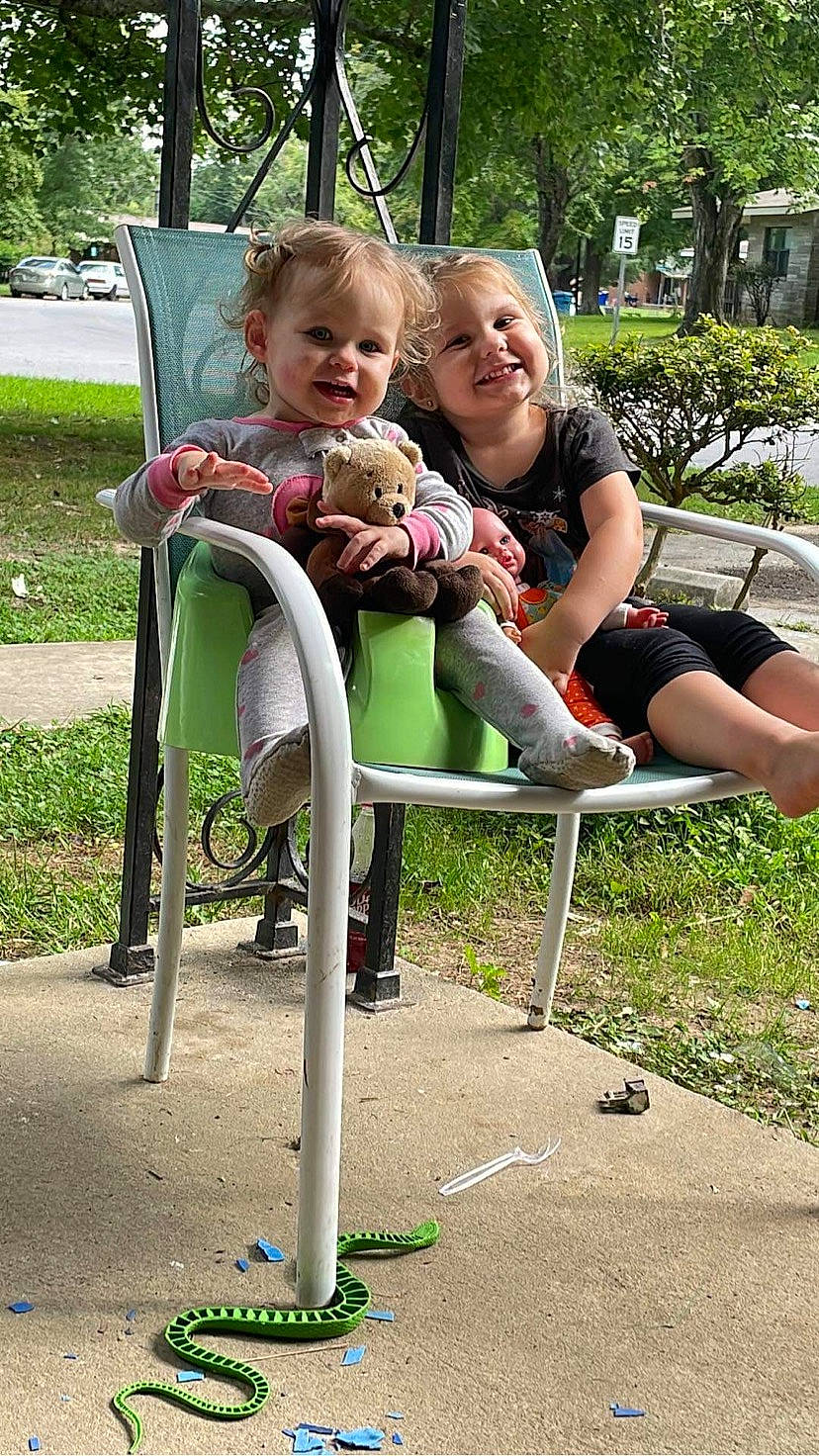 River is registered to the contest to win money with this photo: baby, baby_toddler_clothing, child, city, face, fun, grass, happy, joy, lap, leisure, mammal, outdoor_furniture, people, person, plant, recreation, sitting, smile, summer