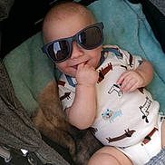 Sawyer joined the competition — help win amazing prizes! baby, infant, child, sunglasses, smiling, stroller, seated, portrait, close_up, casual, indoors, blanket, clothing, onesie, hand, face, head, brown_hair, cute, photography